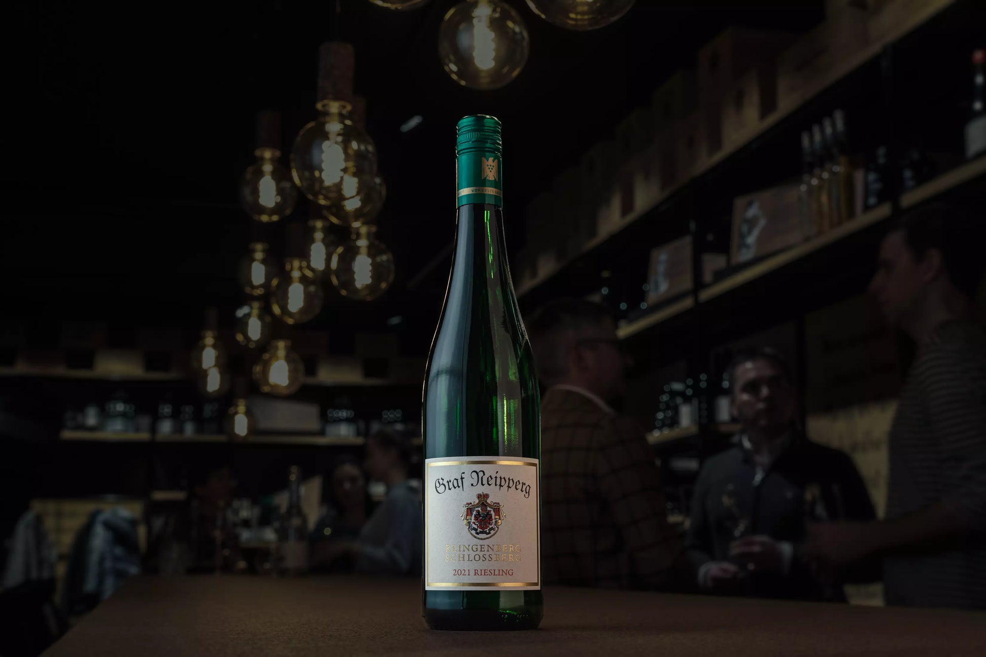 Klingenberger Schlossberg Riesling VDP.Erste Lage vom Weingut Graf Neipperg auf dem Tisch in der dunklen Vinothek Hauser.