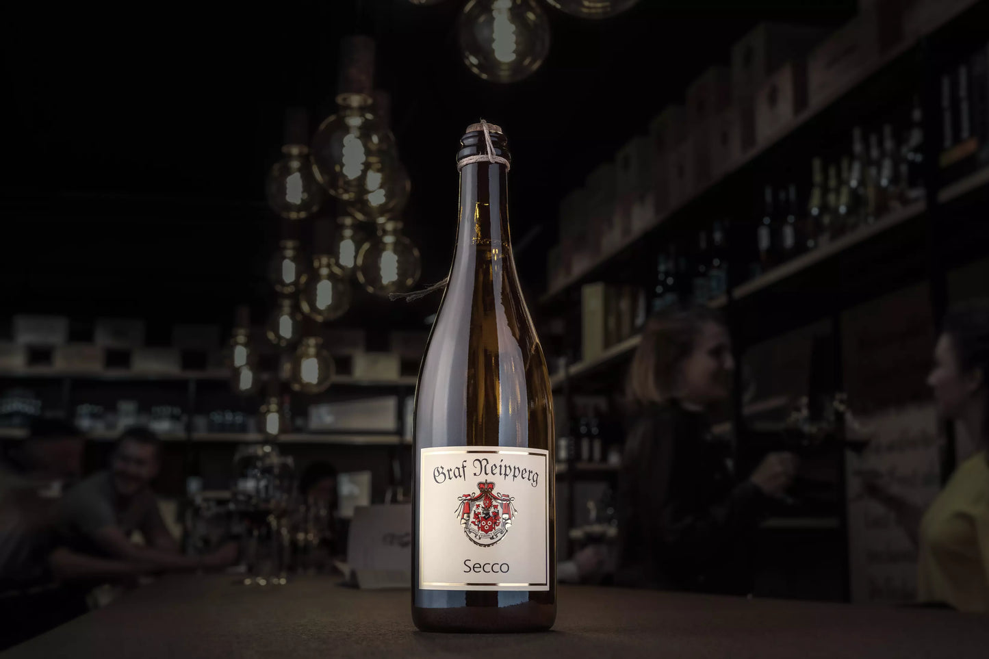 Secco vom Weingut Graf Neipperg auf dem Tisch in der dunklen Vinothek Hauser.