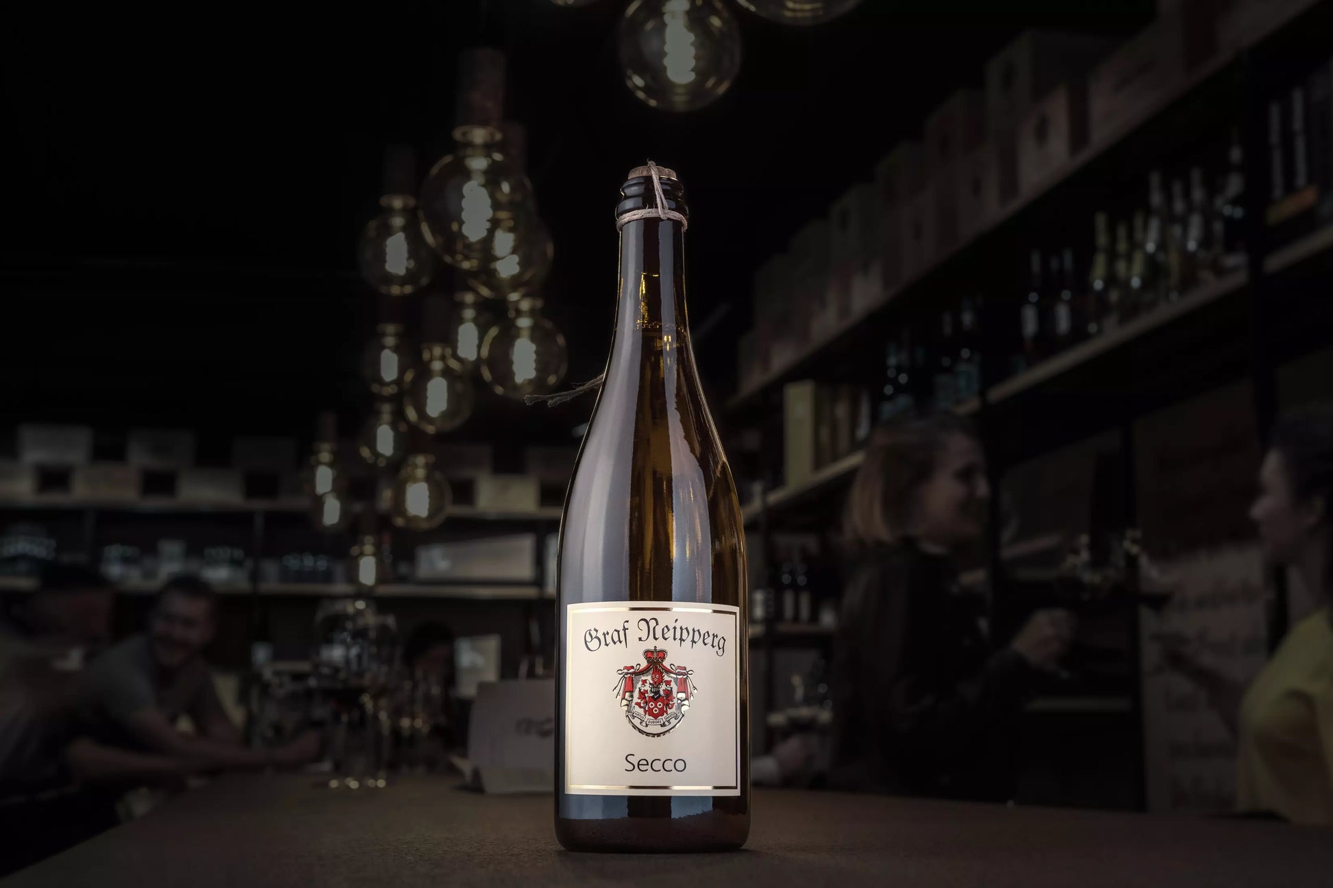 Secco vom Weingut Graf Neipperg auf dem Tisch in der dunklen Vinothek Hauser.