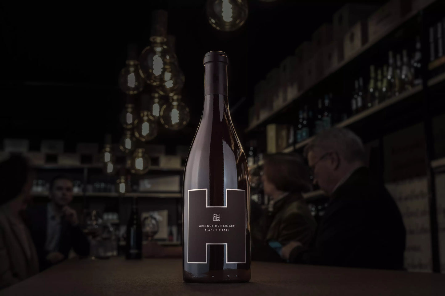 Black Tie vom Weingut Heitlinger auf dem Tisch in der dunklen Vinothek Hauser.