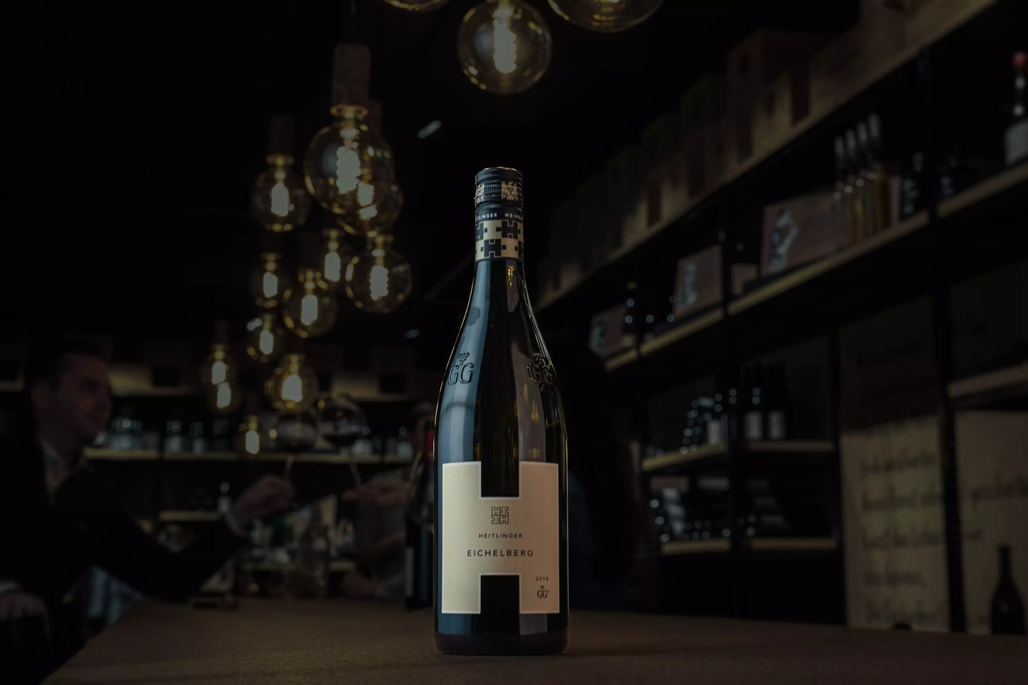Eichelberg Pinot Blanc VDP.GG vom Weingut Heitlinger auf dem Tisch in der dunklen Vinothek Hauser.
