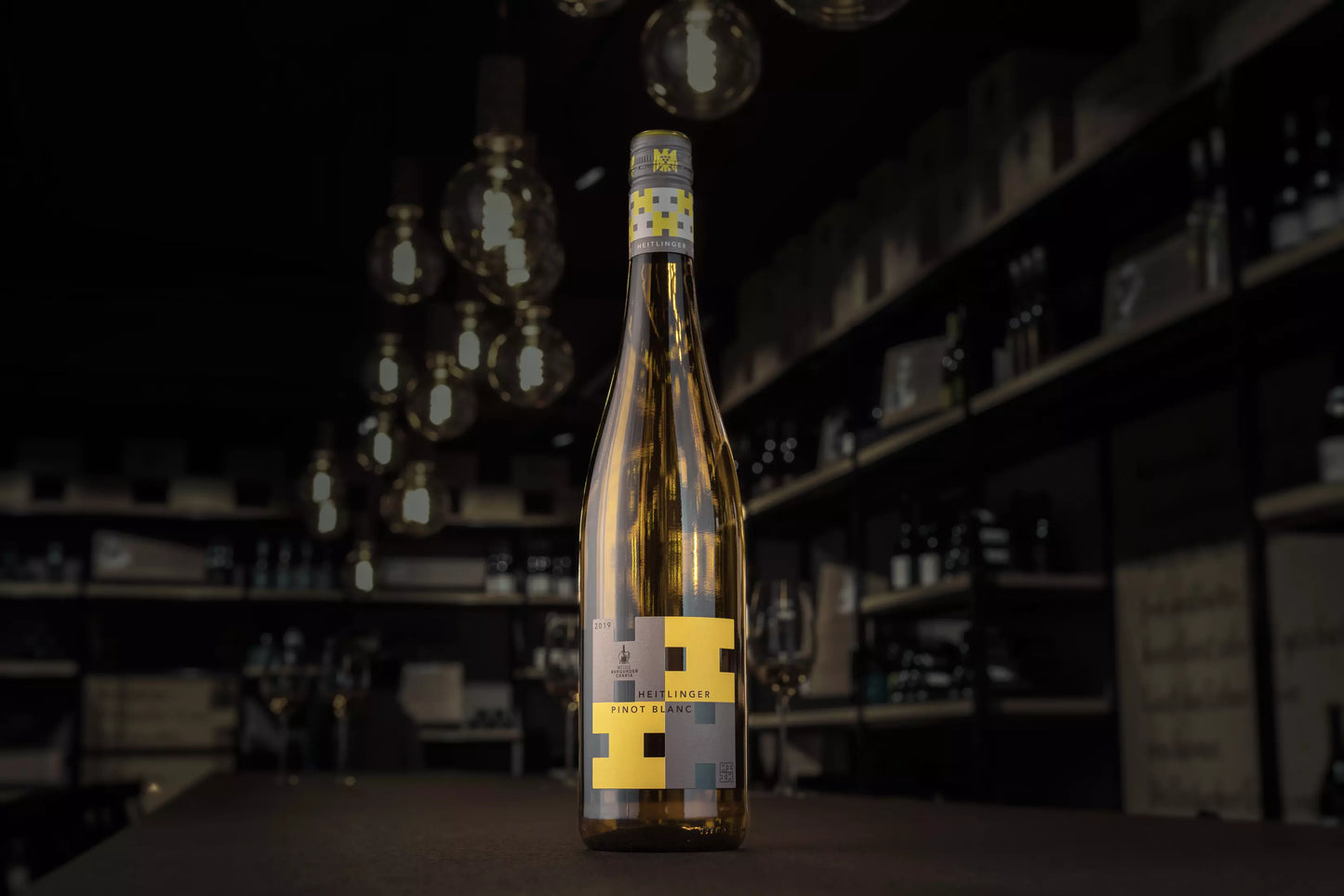 Dunkle Vinothek Hauser mit einer Flasche Pinot Blanc VDP.Gutswein auf dem Tisch im Fokus.