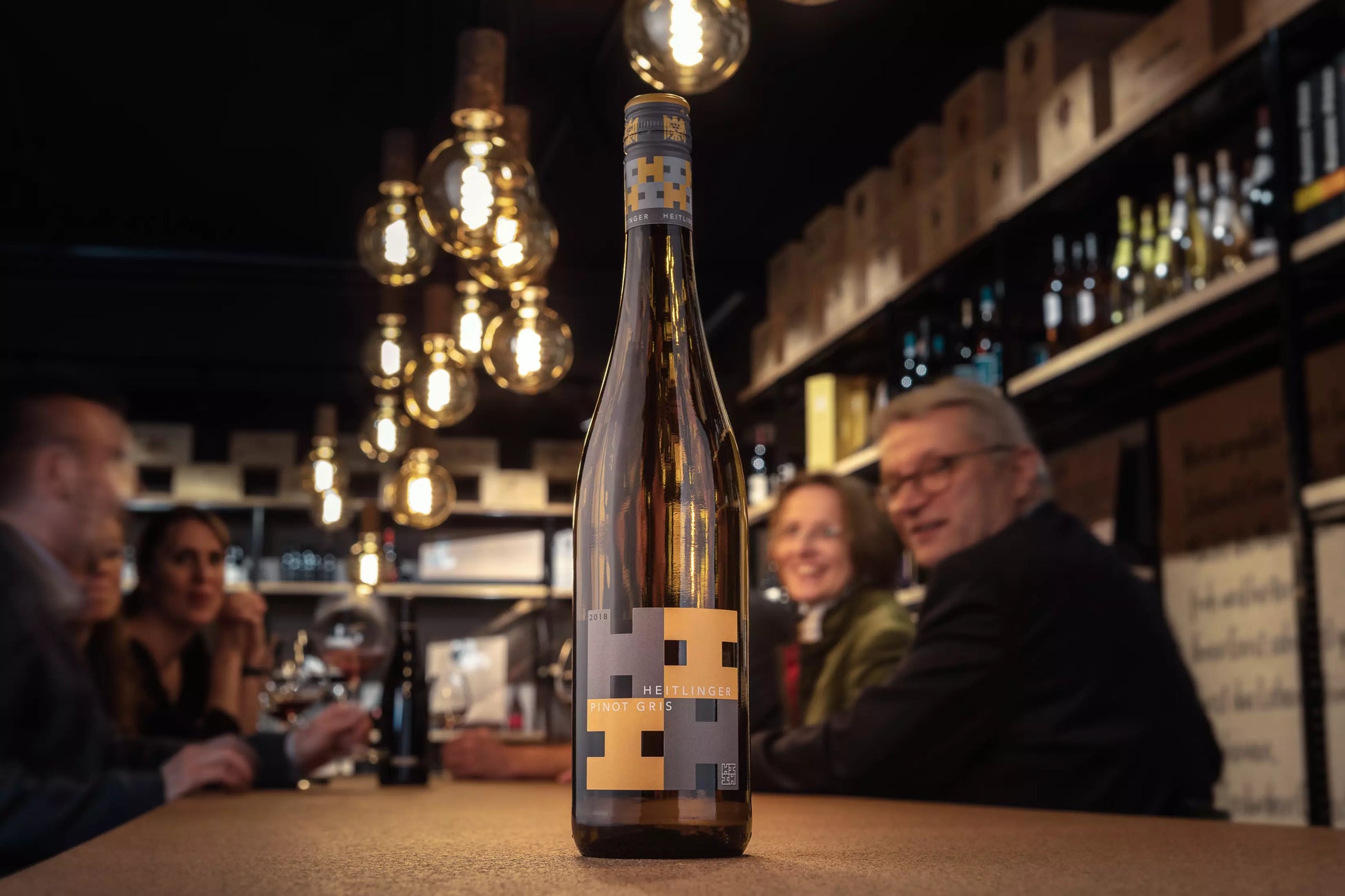 Pinot Gris VDP.Gutswein vom Weingut Heitlinger im Fokus auf dem Tisch in der Vinothek Hauser.