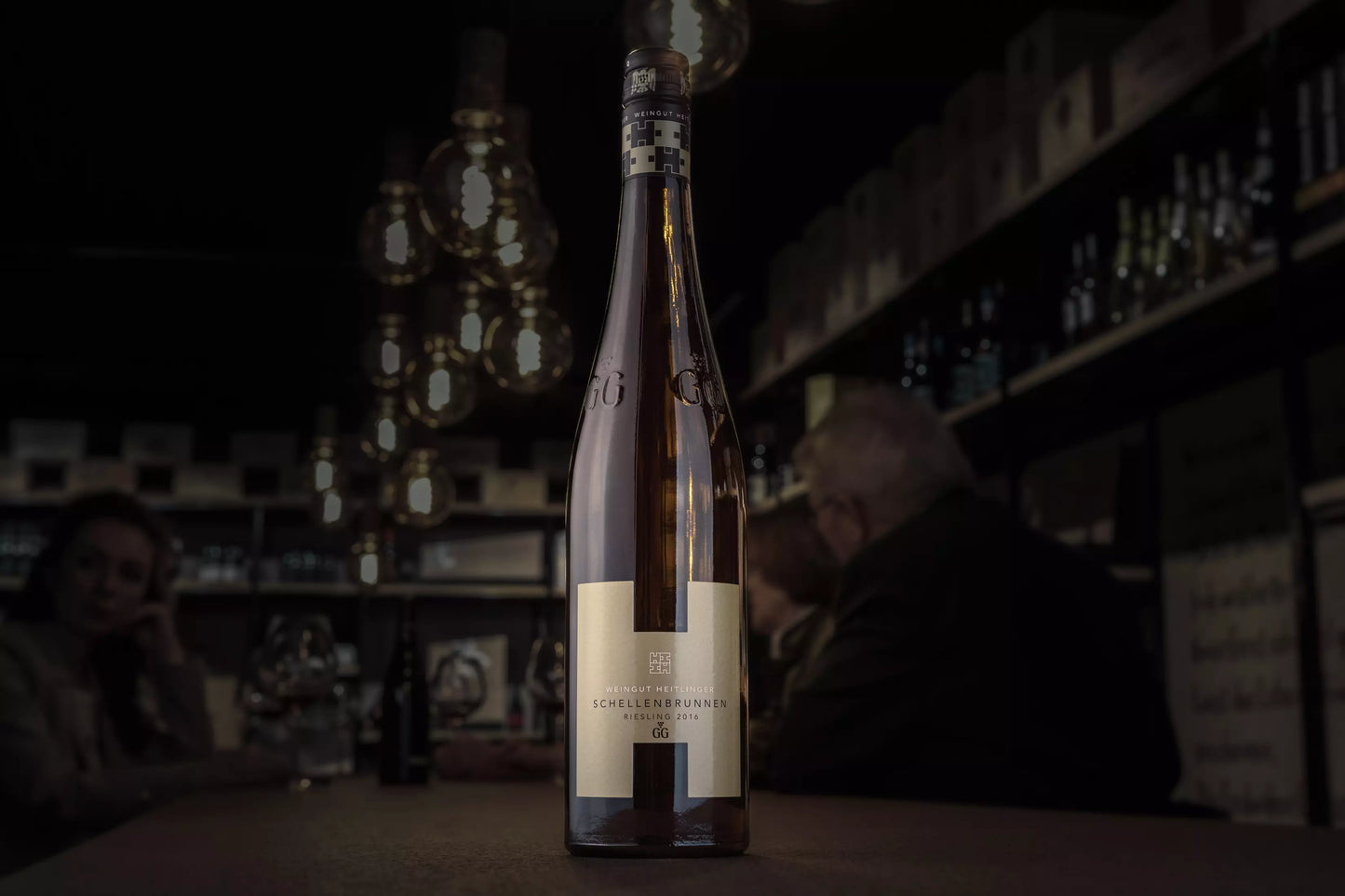 Schellenbrunnen Riesling VDP.GG vom Weingut Heitlinger auf dem Tisch in der dunklen Vinothek Hauser.