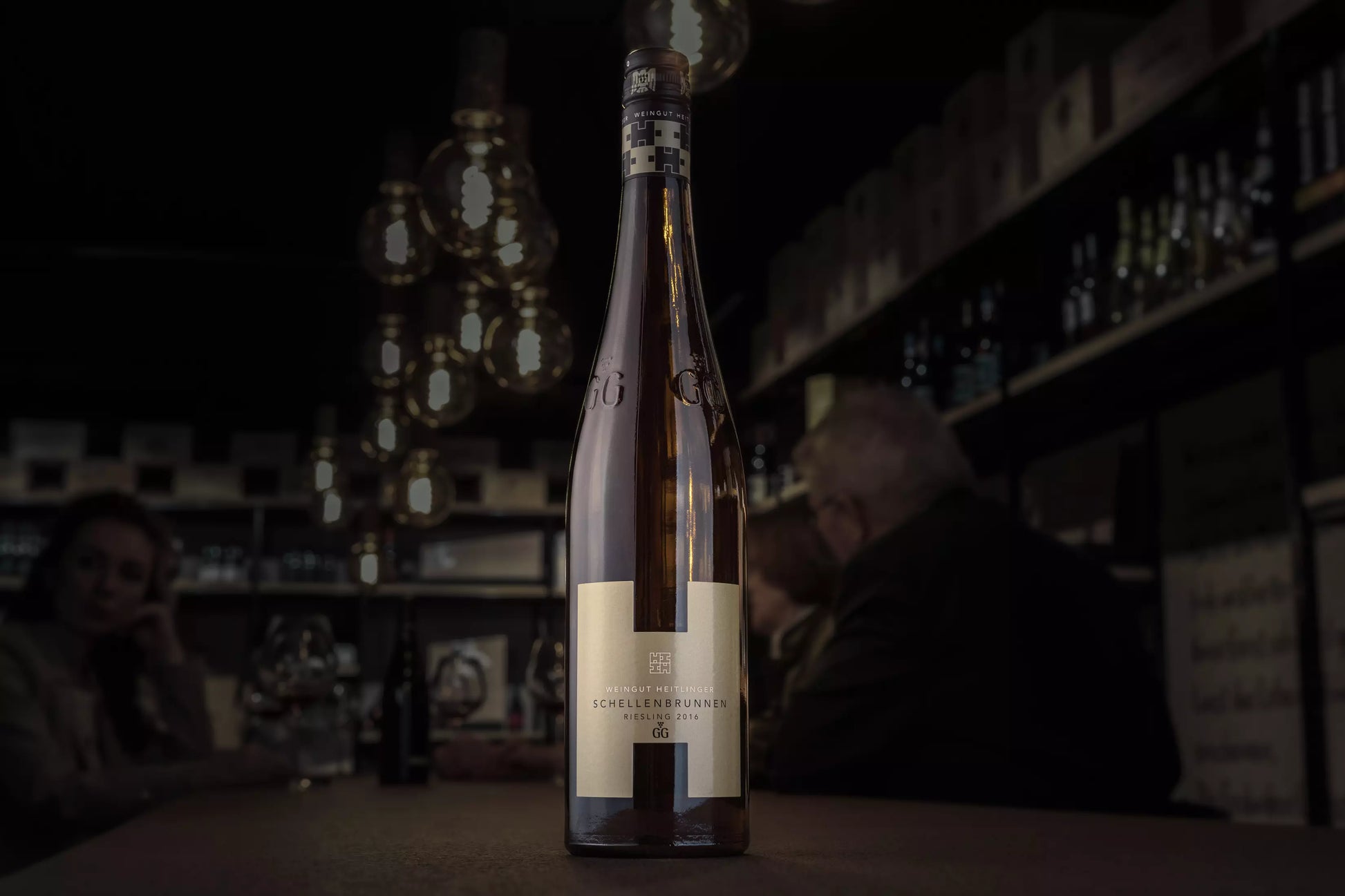 Schellenbrunnen Riesling VDP.GG vom Weingut Heitlinger auf dem Tisch in der dunklen Vinothek Hauser.