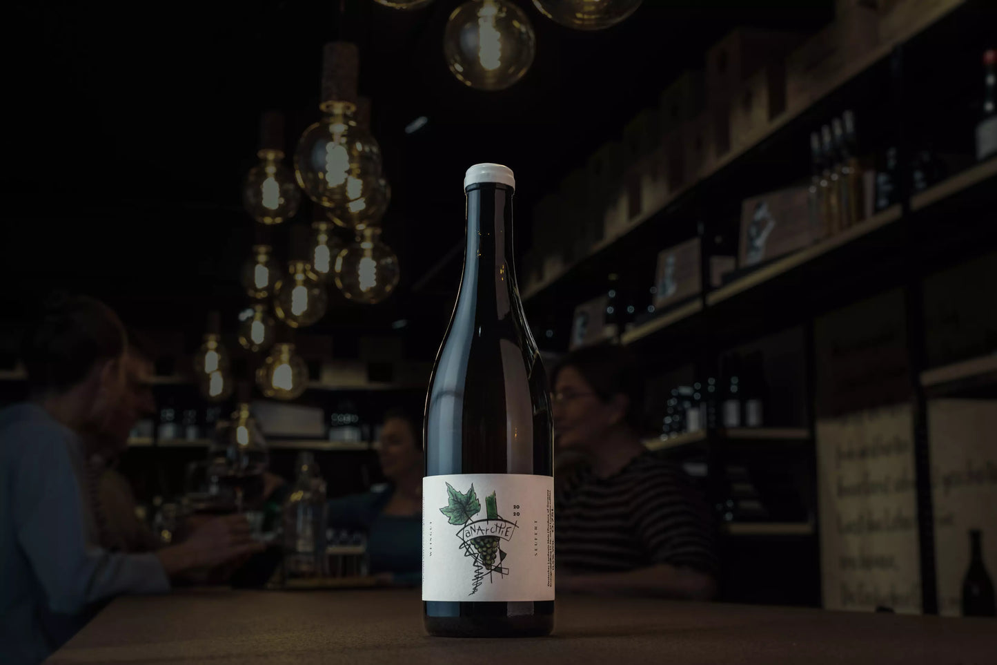 Anarchie Silvaner vom Weingut Laura Seufert auf dem Tisch in der dunklen Vinothek Hauser.