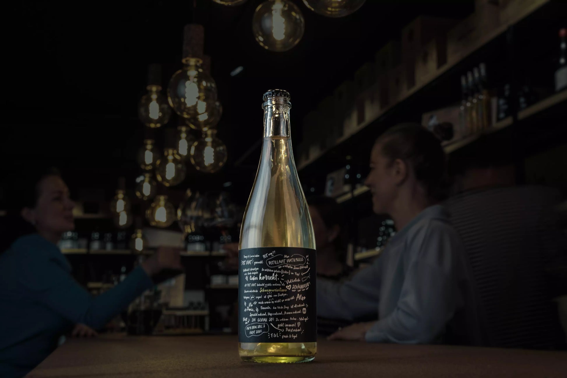 PétNat vom Weingut Franziska Schömig und Weingut Laura Seufert auf dem Tisch in der dunklen Vinothek Hauser.