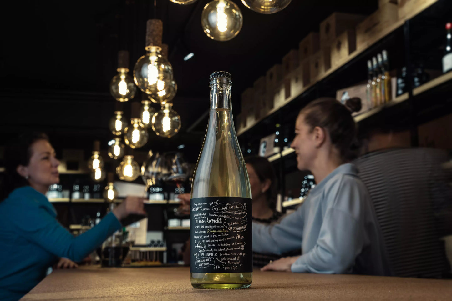 PétNat vom Weingut Franziska Schömig und Weingut Laura Seufert auf dem Tisch in der dunklen Vinothek Hauser.