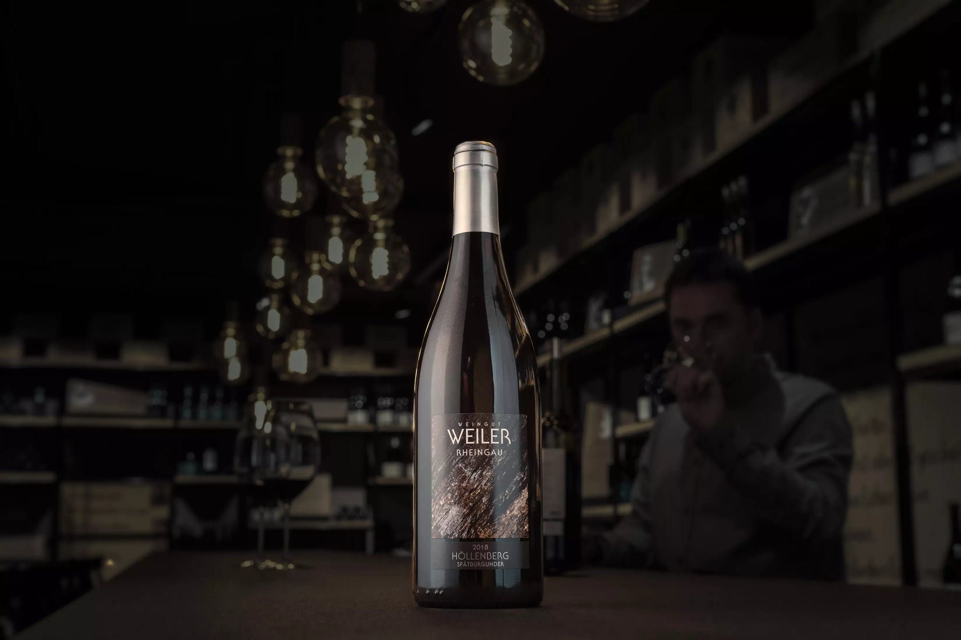 Dunkle Vinothek Hauser mit einer Flasche Assmannshäuser Höllenberg Spätburgunder auf dem Tisch.