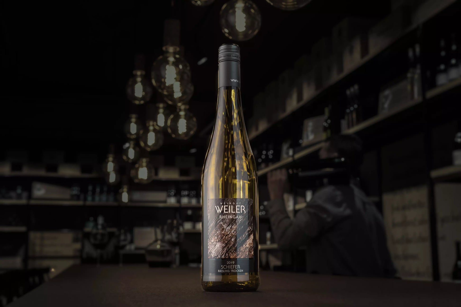 Riesling Schiefer vom Weingut Weiler auf dem Tisch im Fokus in der dunklen Vinothek Hauser.