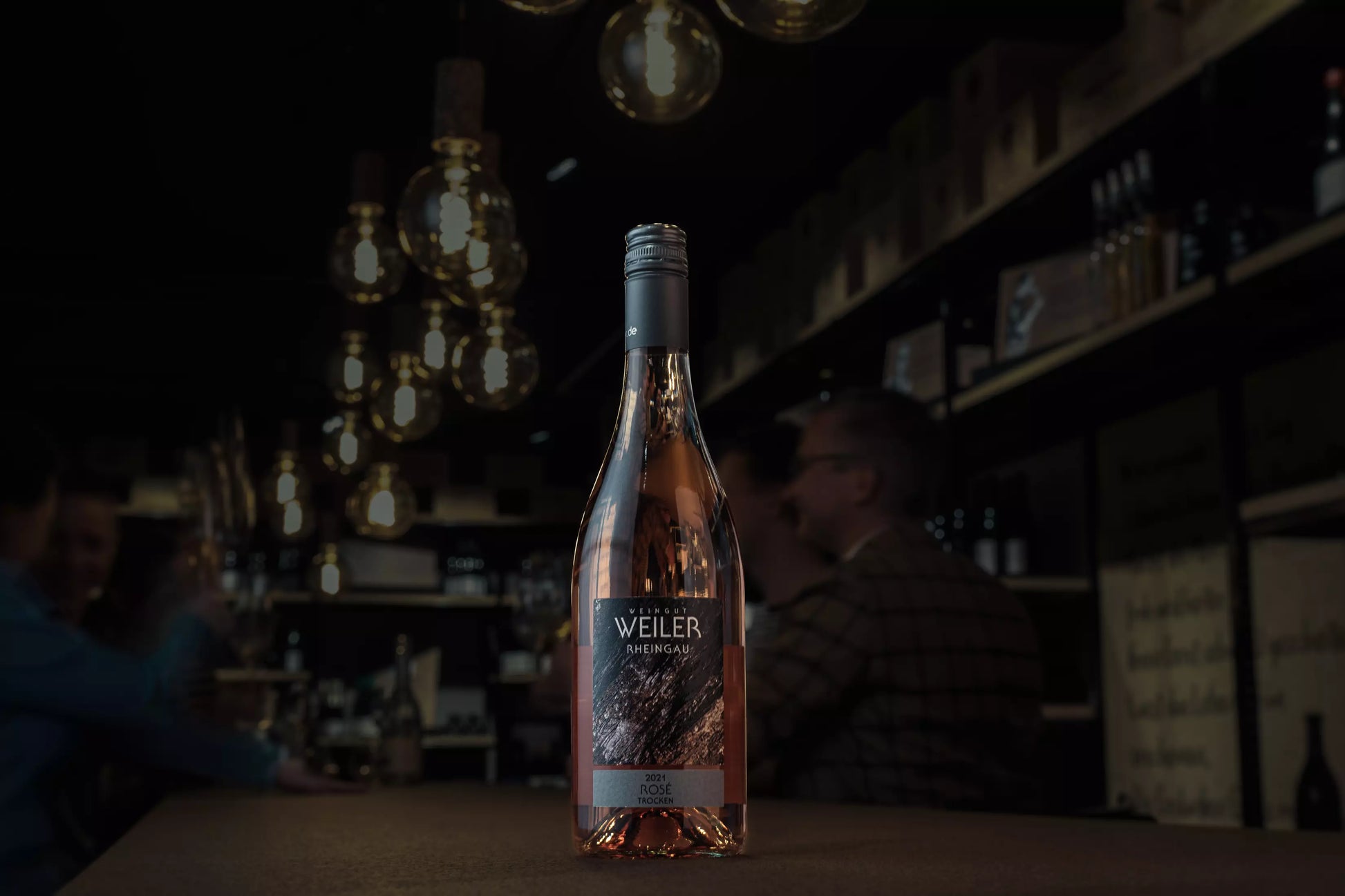 Rosé trocken vom Weingut Weiler auf dem Tisch in der dunklen Vinothek Hauser.