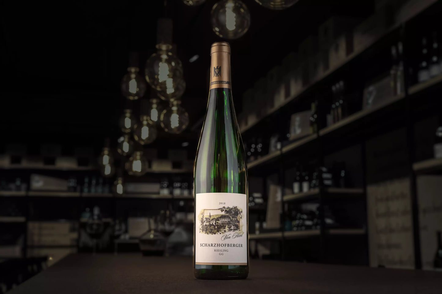 Flasche Scharzhofberg Riesling VDP.Grosses Gewächs vom Weingut von Hövel auf dem Tisch in der dunklen Vinothek Hauser.