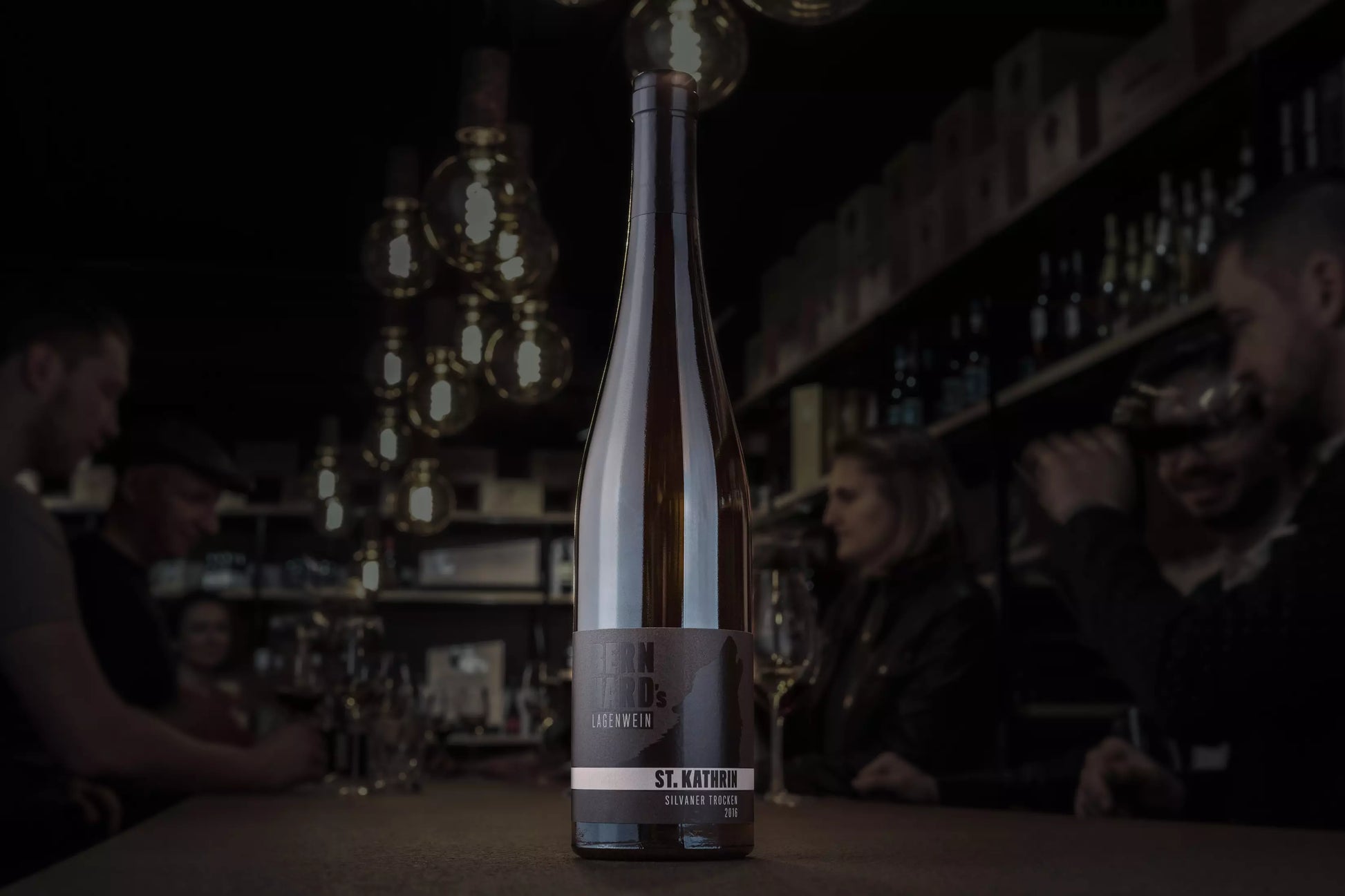 Flasche Sankt Kathrin Silvaner vom Weingut Bernhard auf dem Tisch in der dunklen Vinothek Hauser.
