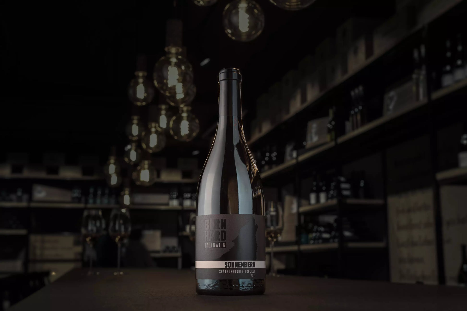 Flasche Sonnenberg Spätburgunder in der dunklein Vinothek auf dem Tisch.