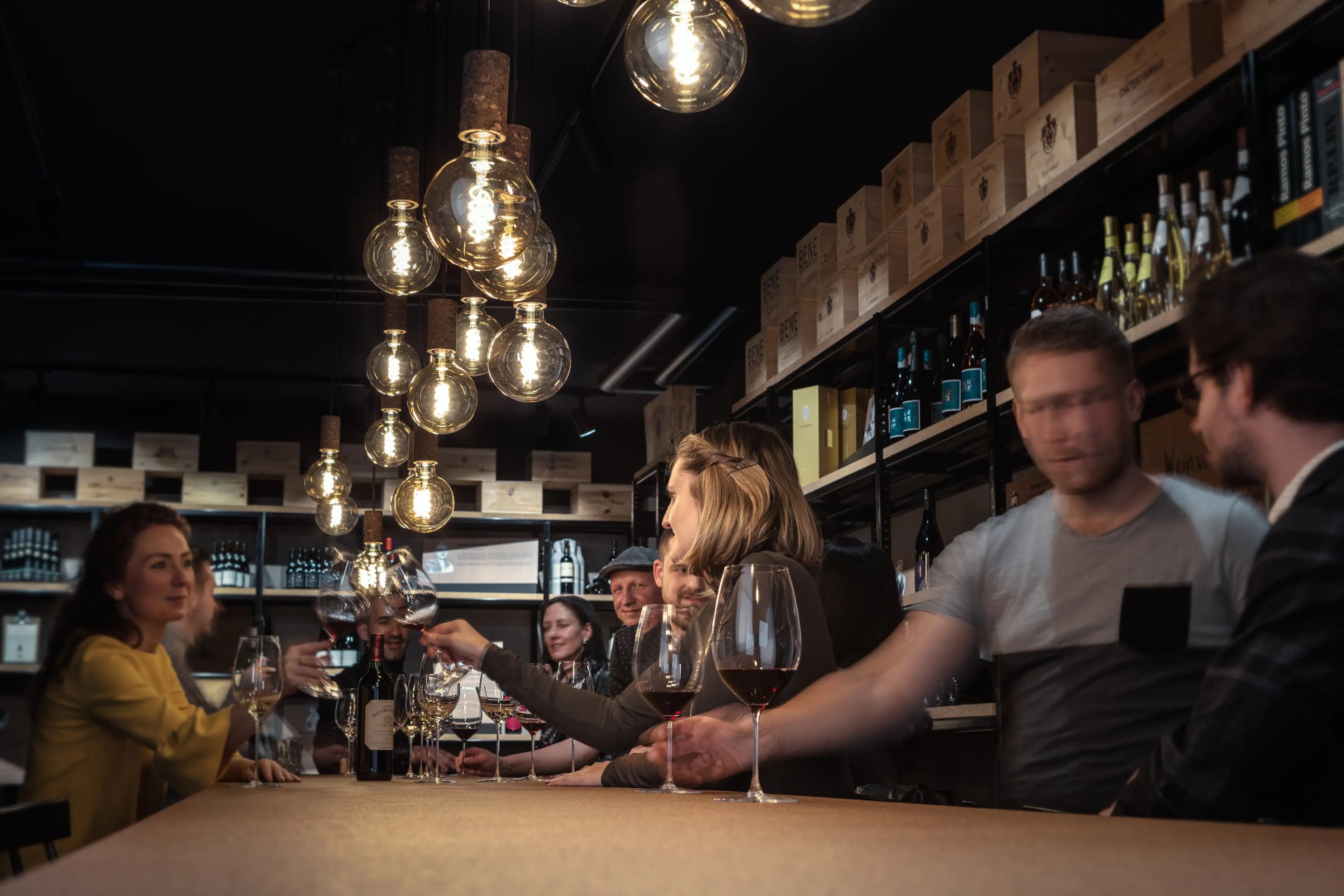 Ambiente in einer Weinhandlung in Luzern, der Vinothek Hauser, mit Gästen beim Apéro am Tisch.